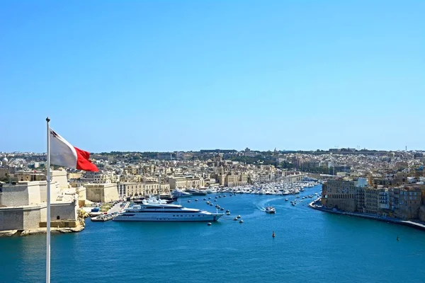 Visa mot Vittoriosa sett från Valletta med en maltesisk flagg i förgrunden, Valletta, Malta. — Stockfoto