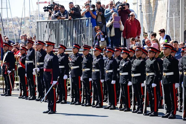 Frihet-firandet med militär personal stå i en kö av pressfrihetens dag monument och paparazzi till baksidaen, Vittoriosa, Malta. — Stockfoto