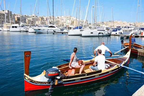 Passagerare ombord på en traditionell maltesisk Dghajsa vatten taxi i hamnen med utsikt mot vattnet Senglea, Vittoriosa, Malta. — Stockfoto