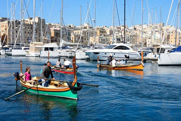 Passagerare ombord på traditionell maltesisk Dghajsa vattentaxi i hamnen med utsikt mot vattnet Senglea, Vittoriosa, Malta. — Stockfoto