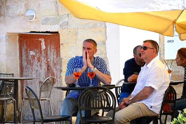 Turystów relaks w kawiarni chodniku wzdłuż nabrzeża, Vittoriosa, Malta. — Zdjęcie stockowe
