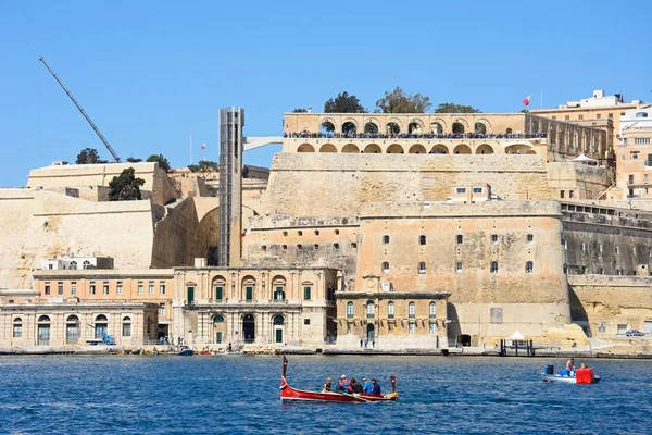 Turister ombord på en traditionell maltesisk Dghajsa vatten taxi med utsikt mot Upper Barrakka Gardens, Valletta, Malta. — Stockfoto