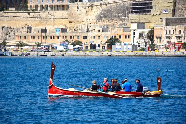 Passengers on board a traditional Maltese Dghajsa water taxi in the grand harbour with views towards Valletta waterfront buildings, Valletta, Malta. — Stock Photo, Image