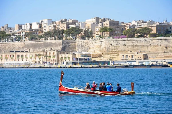 Passengers on board a traditional Maltese Dghajsa water taxi in the grand harbour with views towards Valletta, Vittoriosa, Malta — Stock Photo, Image