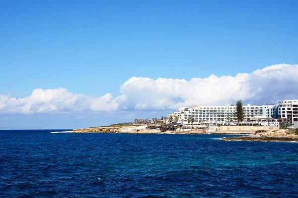 Pohled na skalnaté pobřeží s hotely a apartmány dozadu, Bugibba, Malta. — Stock fotografie