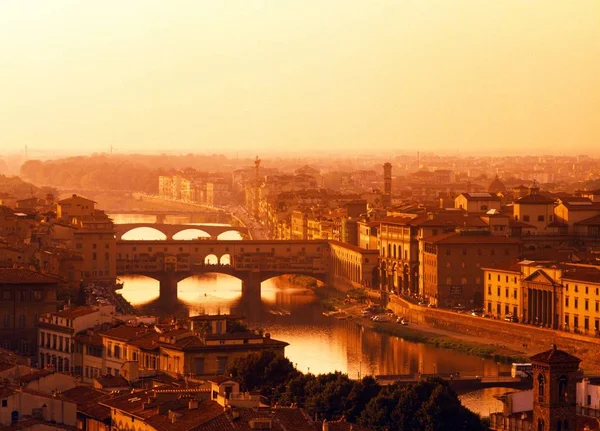 Blick über die Stadt, Ponte Vecchio und den Fluss Arno bei Sonnenuntergang, Florenz, Italien. — Stockfoto
