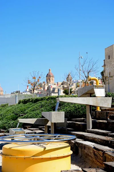 View of waterfront buildings with a modern fountain in the foreground, Vittoriosa, Malta. — Stock Photo, Image