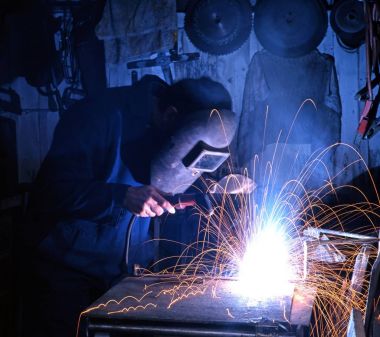 Man welding wearing protective clothing in a workshop, Aldridge, UK. clipart