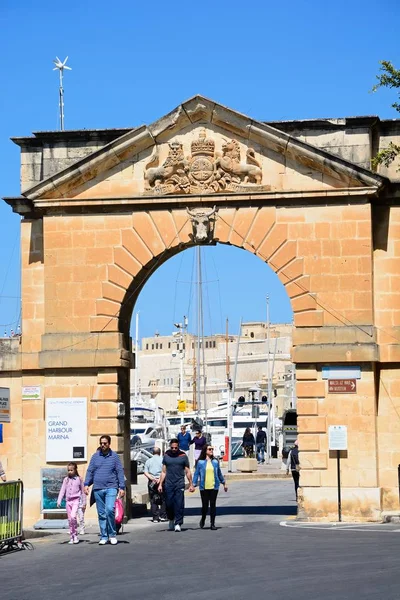 Turister som går genom en båge som leder till Grand Harbour marina, Vittoriosa, Malt. — Stockfoto