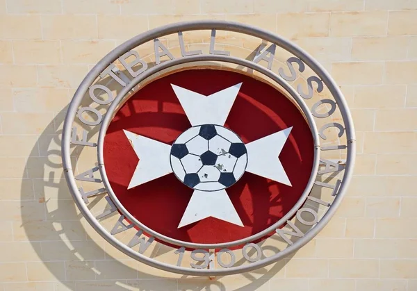 Эмблема футбольной ассоциации Мальты на фасаде стадиона Столетия, Аттард, Мальта . — стоковое фото
