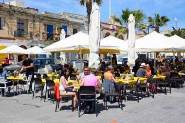Turistler limanda Marsaxlokk, Malta boyunca kaldırım kafeleri, rahatlatıcı.