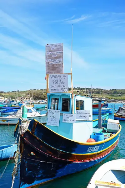 Barco de pesca tradicional maltés Dghajsa en el puerto con protestas contra MAF, Marsaxlokk, Malta . — Foto de Stock