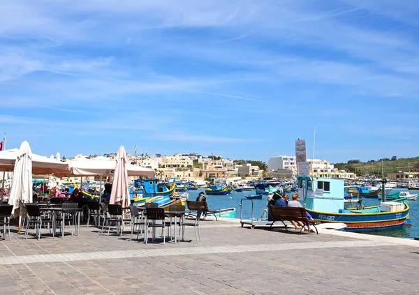 Παραδοσιακό Μάλτας Dghajsa αλιευτικά σκάφη στο λιμάνι με κτίρια στην προκυμαία στο οπίσθιο τμήμα και τα εστιατόρια στην προκυμαία, Marsaxlokk, Μάλτα. — Φωτογραφία Αρχείου