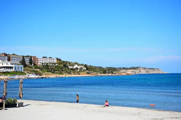 Turistas relajándose en la playa con la costa en la parte trasera, Mellieha, Malta . —  Fotos de Stock