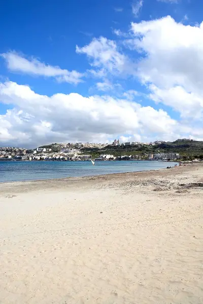 View of the sandy beach with town buildings across the bay, Mellieha, Malta. — Stock Photo, Image