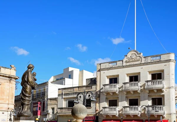 Estatua en frente de la cúpula de Mosta con los antiguos edificios de cine Paramount en la parte trasera alrededor de la Plaza de la Rotonda en el centro de la ciudad, Mosta, Malta . —  Fotos de Stock