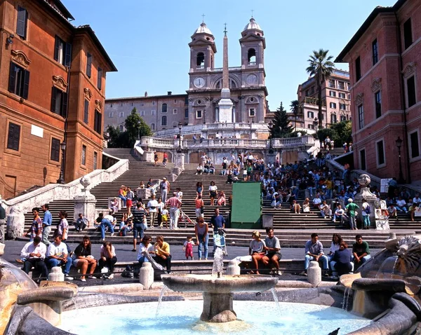 Turister som sitter på Spanska trappan med en fontän i förgrunden, Rom, Italien. — Stockfoto