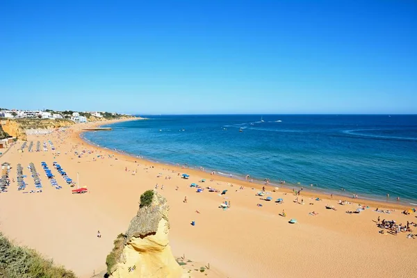 Forhojd utsikt stranden med turister njuter inställningen, Albufeira, Portugal. — Stockfoto