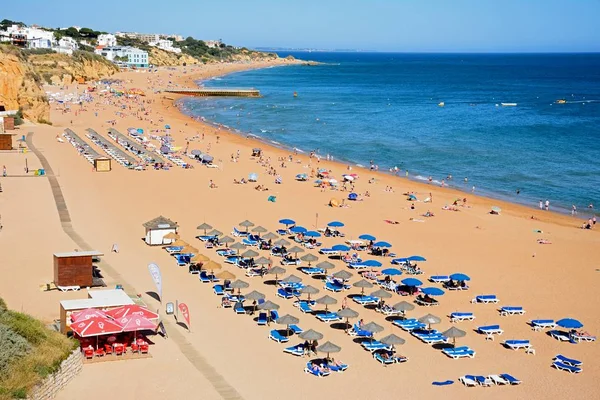 Pohled na pláž s turisty těší nastavení a město budovy, dozadu, Albufeira, Portugalsko. — Stock fotografie
