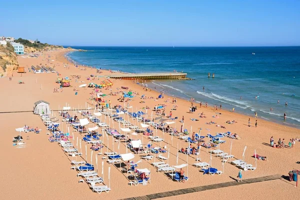 Forhojd utsikt stranden med turister njuter inställningen, Albufeira, Portugal. — Stockfoto