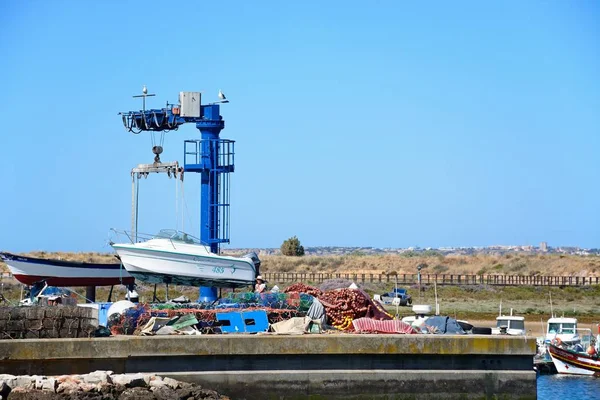 Bateau à moteur dans une grue dans le port de pêche, Alvor, Algarve, Portugal . — Photo