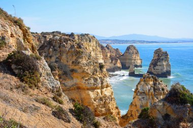 Yükseltilmiş görünümü engebeli kıyı şeridi ve kayalıklarla, Ponta da Piedade, Portekiz.