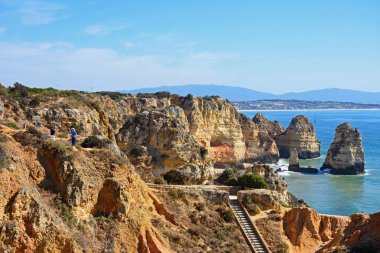 Engebeli kıyı şeridi ile yükseltilmiş görünümü ön planda, Ponta da Piedade, Portekiz adımlar.