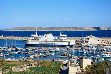 Tekneler ve yatlar Balık tutma arka Mgarr, Gozo, Malta limanında demirlemiş Gozo feribot ile limanda palamarla.