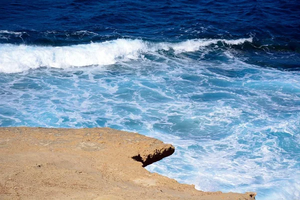 Rozeklané skály převisu nad mořem, pevnůstka, Marsalforn, Gozo, Malta. — Stock fotografie