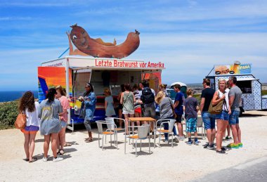 Durak, Cape St Vincent, Portekiz bir Alman sosisleri queuing turist snack.