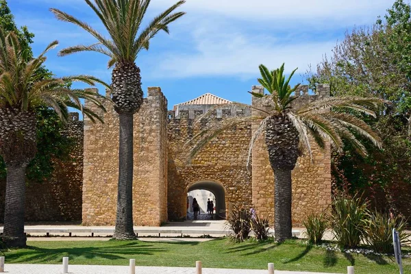 Görünüm ön plan ve ayarı, Lagos, Portekiz zevk turistlerin palmiye ağaçları ile valilerin kalenin giriş Arch.