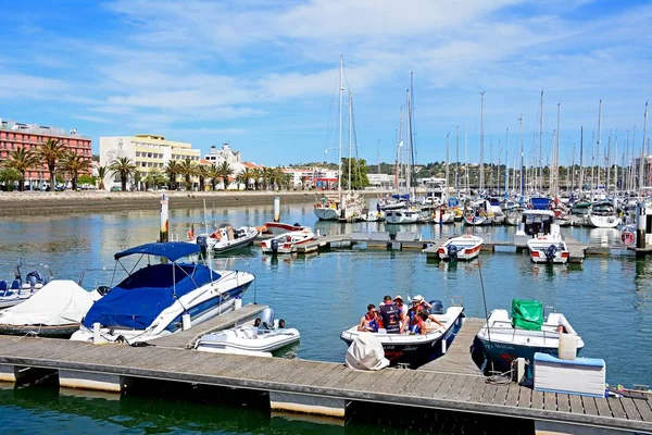 Båtar och yachter förtöjd i marina de Lagos med människor som njuter inställningen, Lagos, Portugal. — Stockfoto