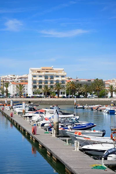 Barcos amarrados contra un pontón con edificios urbanos en la parte trasera del puerto deportivo de Lagos, Lagos, Portugal . — Foto de Stock