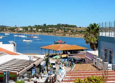 Balık pazarı ve Haliç, Alvor, Portekiz doğru manzaralı Restoran kaplı sokak.