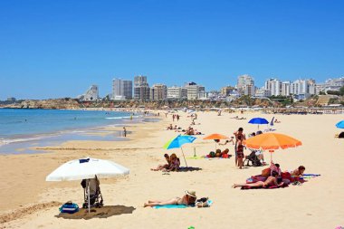 Daire ve otel arka ve ayarı, Portimao, Portekiz zevk turist ile plaj boyunca görüntülemek.