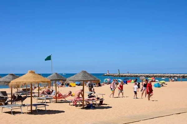 在海滩上放松的游客对海港入口防波堤的看法, 维拉摩拉, 葡萄牙. — 图库照片