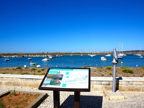 Rybářské čluny a jachty kotvící v ústí s plánem přírody v popředí, Alvor, Portugalsko. — Stock fotografie