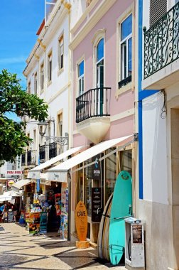 Dükkan ve kaldırım kafeleri boyunca R 25 de Abril alışveriş caddesi eski şehir, Lagos, Algarve, Portekiz.