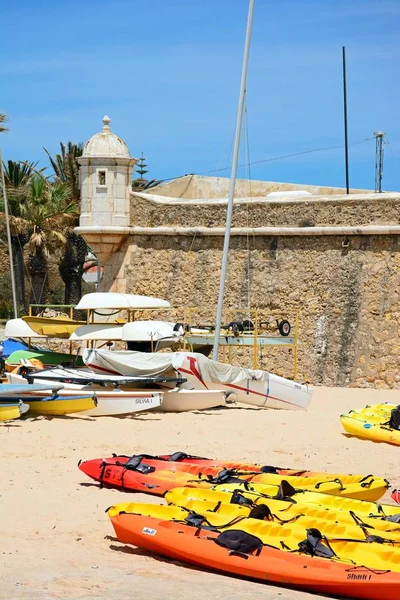 Vista de la fortaleza de Ponta da Bandeira con canoas en la playa en primer plano, Lagos, Algarve, Portugal . — Foto de Stock
