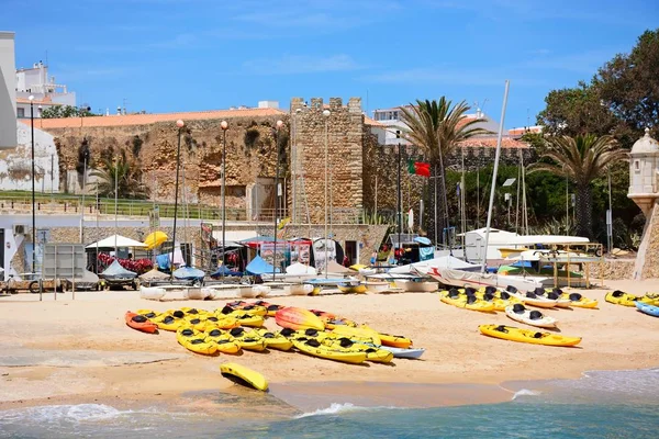 Pohled guvernéři palác s kanoí na pláži v popředí a věž na Ponta da Bandeira pevnost na pravém straně, Lagos, Algarve, Portugalsko. — Stock fotografie