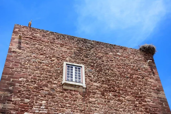 Cigüeñas anidando en la parte superior del edificio de la puerta de la ciudad, Silves, Portugal . — Foto de Stock