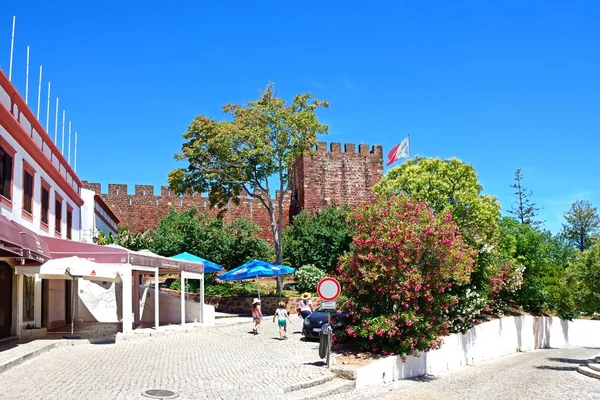 Vista del castillo medieval con turistas caminando por una calle de la ciudad en primer plano, Silves, Portugal . —  Fotos de Stock