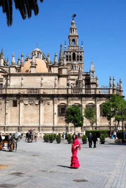 Batı Katedrali ve Giralda Kulesi önünde Flamenko elbiseli bir kadınla, Seville, İspanya.