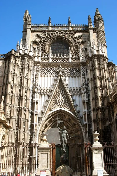 Entré till katedralen med en staty i förgrunden, Sevilla, Spanien. — Stockfoto