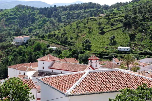 Blick über die Dächer des Dorfes auf die baumbestandenen Berge, Atajate, Spanien. — Stockfoto