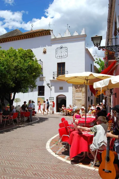 Turistas relajándose en cafeterías en la Plaza de Orange con la oficina de turismo en la parte trasera, Marbella, España . — Foto de Stock