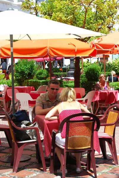 Turistas relajándose en cafeterías en Orange Square, Marbella, España . — Foto de Stock