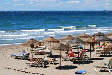Akdeniz manzaralı Daitona sahillerinde dinlenen turistler, Marbella, İspanya.