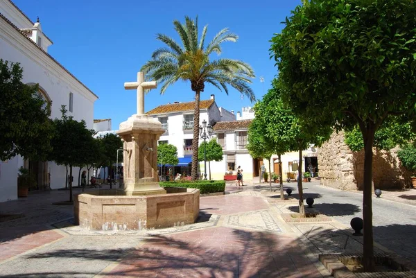 Stone fountain in Church Square with the Santa Maria church to the left, Marbella, Spain. — 图库照片