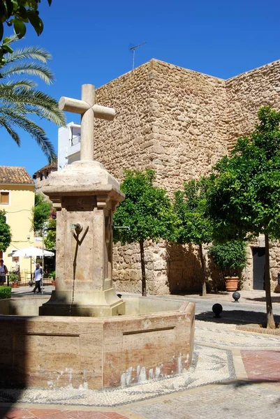Stone fountain in Church Square with the castle wall to the rear, Marbella, Spain. — Stockfoto